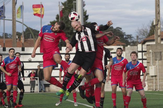 Nando, del Escobedo, salta al remate de cabeza rodeado de jugadores del Solares. 