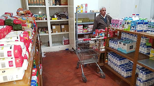 Uno de los voluntarios de Cáritas de Los Corrales prepara sus despensas de alimentos básicos.