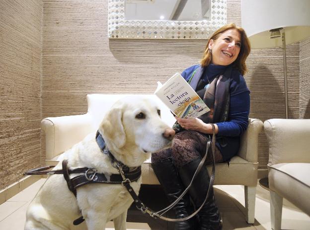 Paqui Ayllón posa con su libro acompañada por 'Meadow', su perra guía.