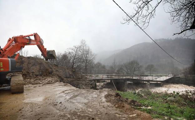 El argayo provocado por las fuertes lluvias dañó el puente sobre el río Saja.