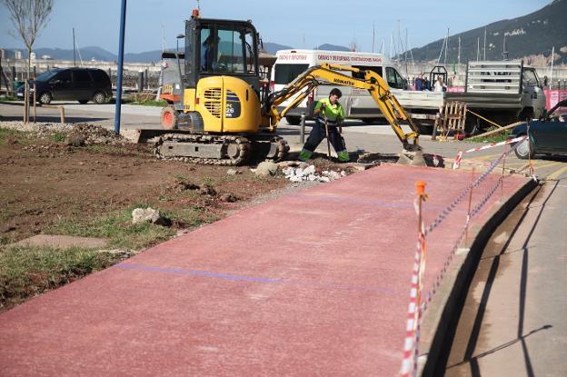 Los operarios trabajan en la ejecución del carril bici que conectará el puerto con el paseo marítimo de la playa.
