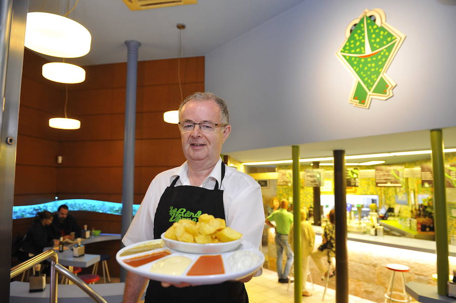 Félix Gómez con uno de los platos estrella de la Rana Verde: patatas fritas con varias salsas.