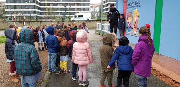 El policía de Santoña Raúl Saiz ha acudido al centro para enseñar a los escolares a medirse en el mural. 