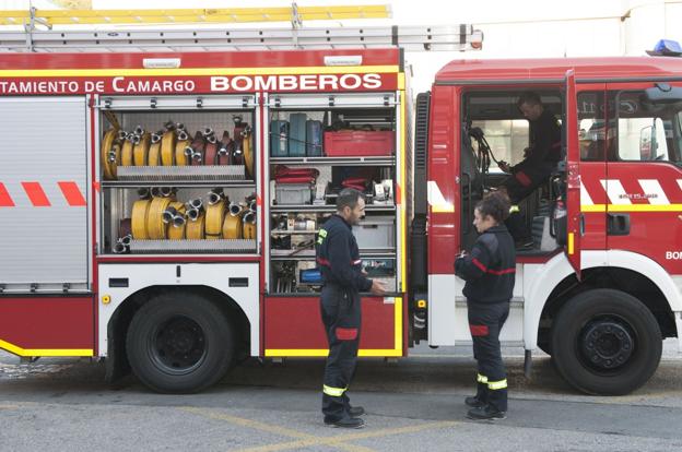 Miembros del cuerpo de bomberos de Camargo, en uno de los vehículos de extinción de incendios del parque.