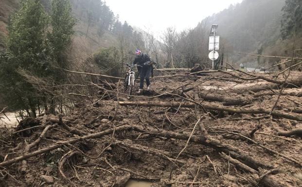 Un ciclista intenta pasar por el argayo de la N-611. 