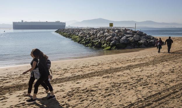 Paseantes por la playa de La Magdalena junto a la escollera construida entre enero y junio de 2018. 