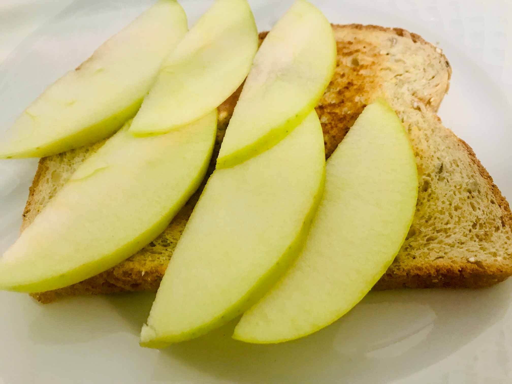 Tostada de manzana y huevo. 2-Trocear la manzana. Tostar el pan de semillas.