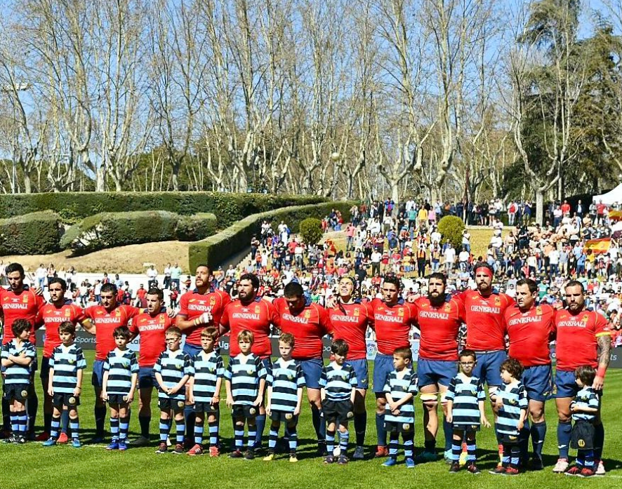 Mora, cuarto por la izquierda, escucha el himno español antes del partido.