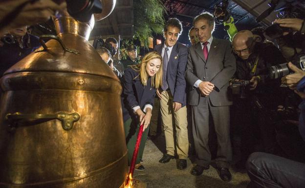 La actriz Marta Hazas, orujera mayor, enciende la alquitara, junto a Francisco Martín y Javier Gómez en la Fiesta del orujo de 2015.