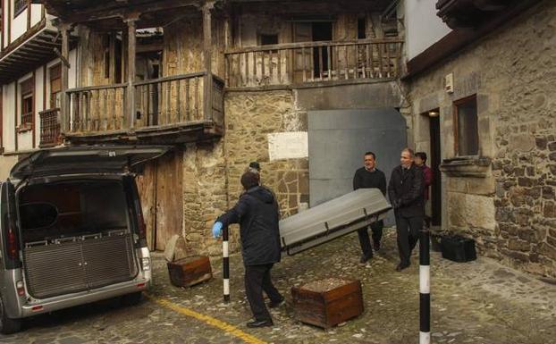 Operarios de la funeraria trasladan el féretro, ayer en la calle Obispo de Potes. 