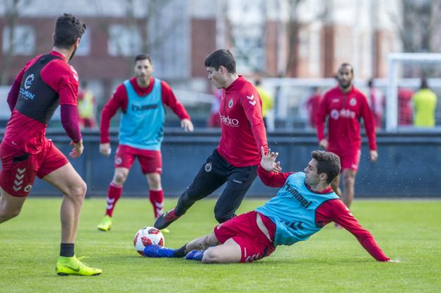 Óscar Gil se lanza al suelo para quitar el balón a Sergio Ruiz en la sesión de este miércoles en La Albericia.