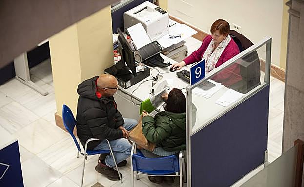 Una pareja efectúa una consulta en una de las mesas de la Delegación de Hacienda en Cantabria.