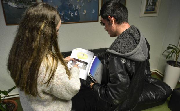 Dos alumnos leyendo las instrucciones de la nueva normativa. 