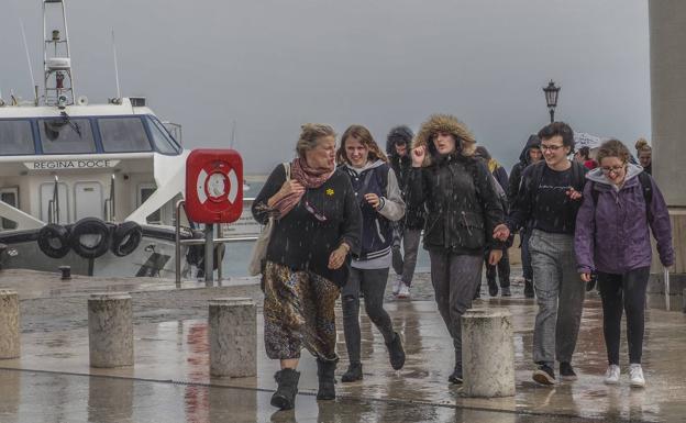 La lluvia cogió por sorpresa a los paseantes por Santander a primera hora de la tarde. 