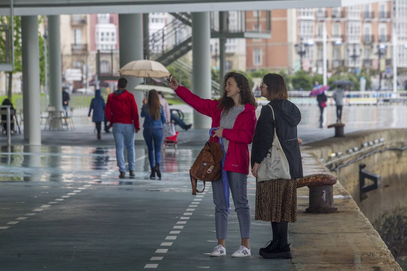 Imágenes de turistas paseando por Santander este lluvioso Jueves Santo