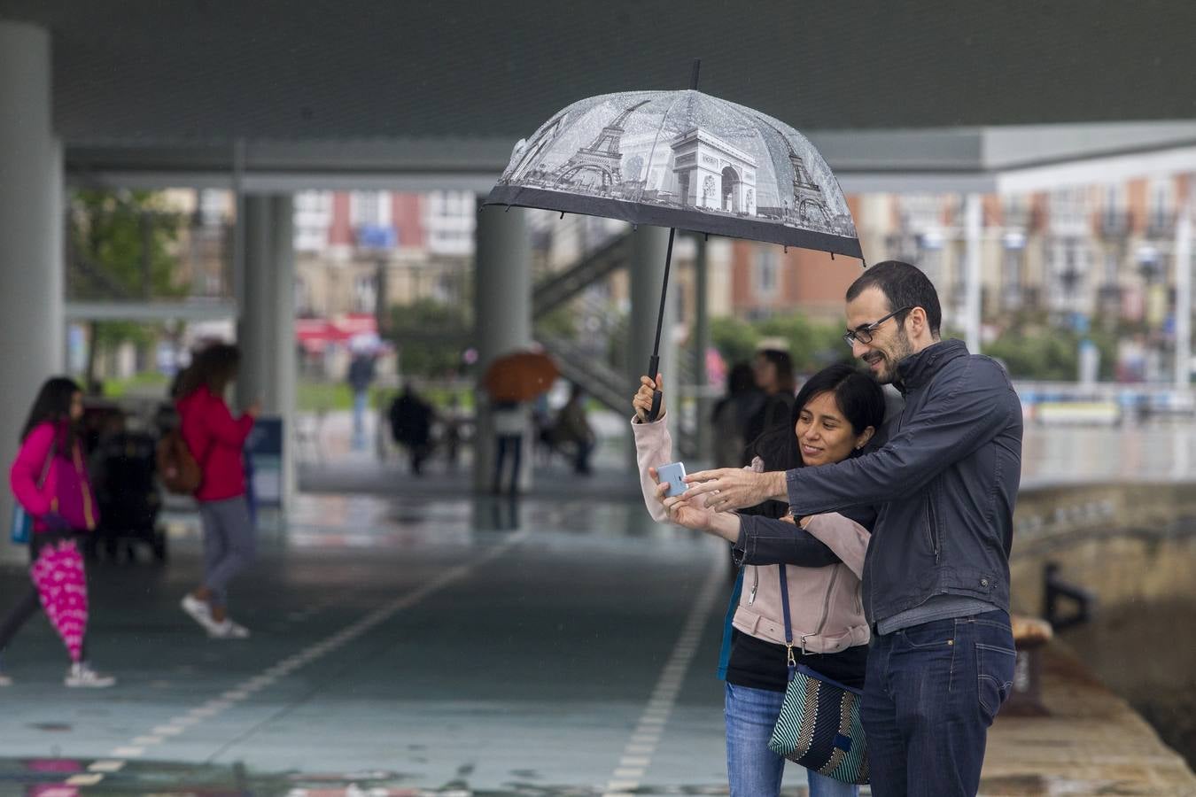 Imágenes de turistas paseando por Santander este lluvioso Jueves Santo