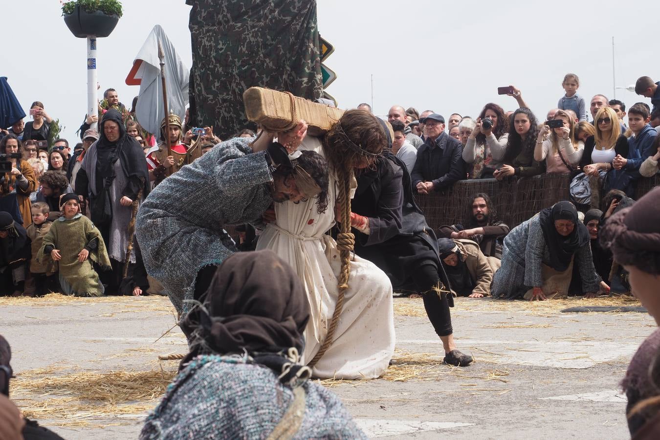 Algunos judíos ayudan a Jesús con el peso de su cruz.