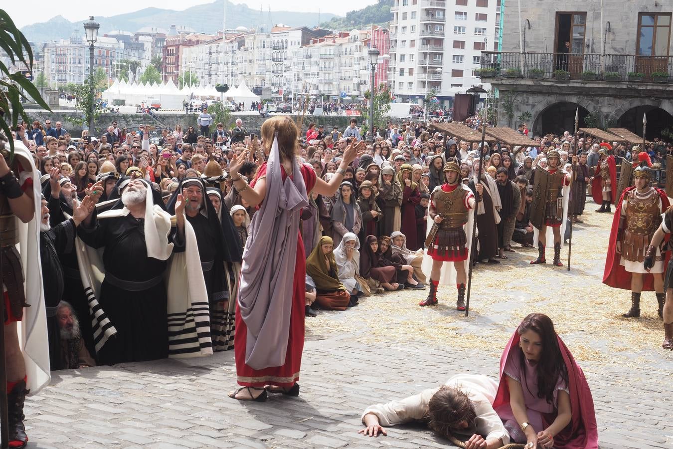 María Magdalena habla a los que han juzgado a Jesús mientras Verónica le ayuda a levantarse.