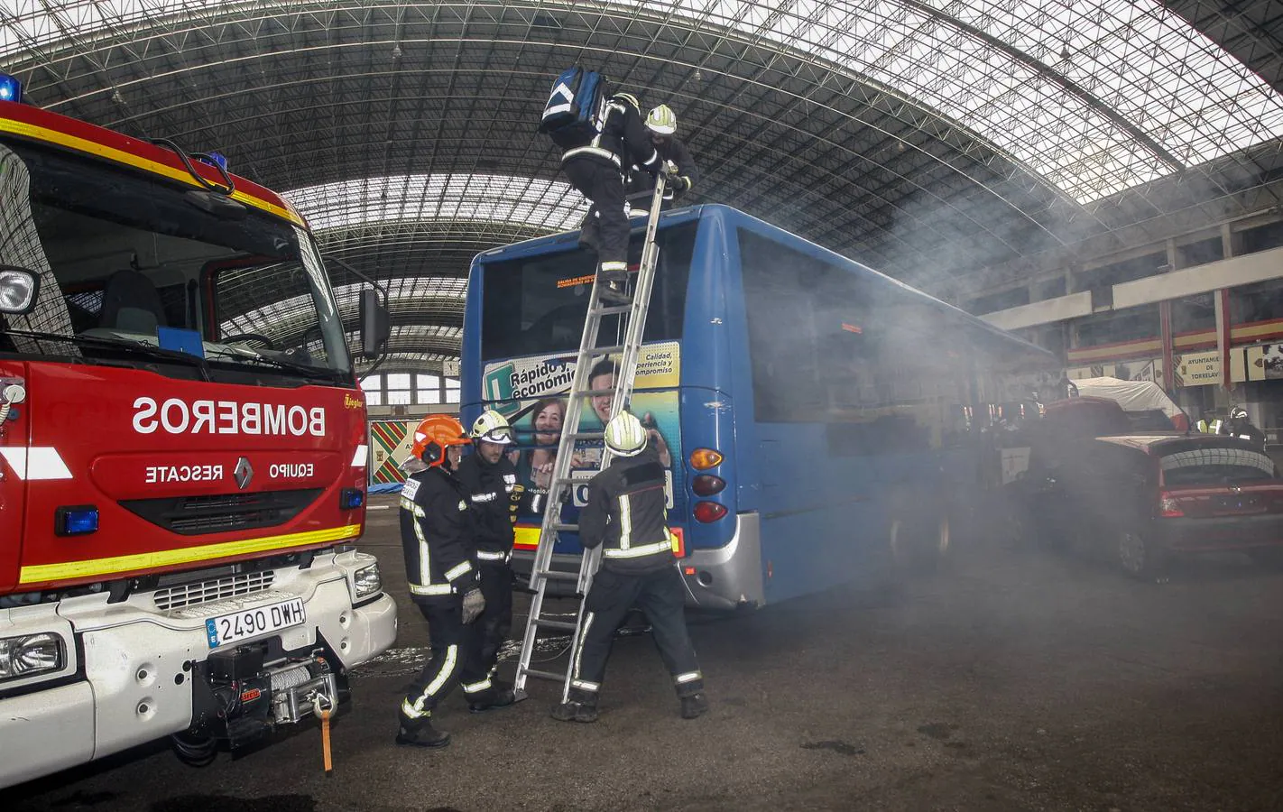 Los bomberos usan una escalera para acceder al interior del autobús.