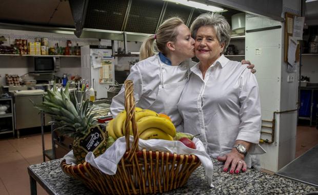 Cristina besa a su madre Amparo en la cocina del restaurante 'Villa de Santillana'. 