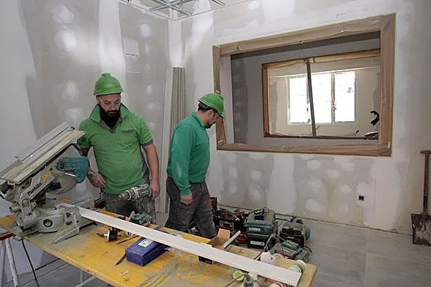 Dos operarios trabajan en el acondicionamiento del local donde se ubicará el Punto de Encuentro Familiar.
