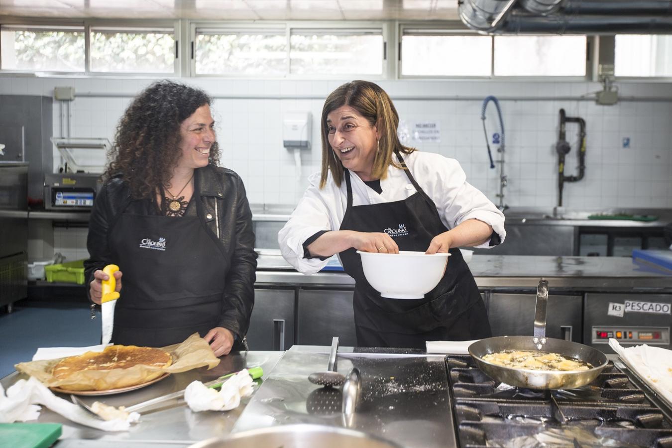 María José Sáenz de Buruaga y Mónica Rodero bromean mientras preparan sus platos.