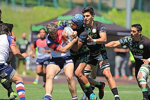 Green (derecha) lucha por el oval con un rival del Liceo.