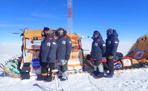 Los cuatro expedicionarios españoles en el trineo de viento, con unos de los aparatos de la Agencia Espacial Europea.