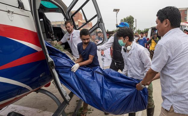 Policías nepalís y miembros de los servicios de rescate transportan el cuerpo de uno de los escaladores fallecidos.