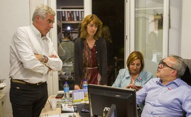 Fuentes-Pila (a la izquierda) cambia impresiones con varios compañeros de partido durante la noche electoral.