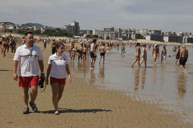 Dos socorristas de Cruz Roja vigilan la playa Salvé de Laredo.