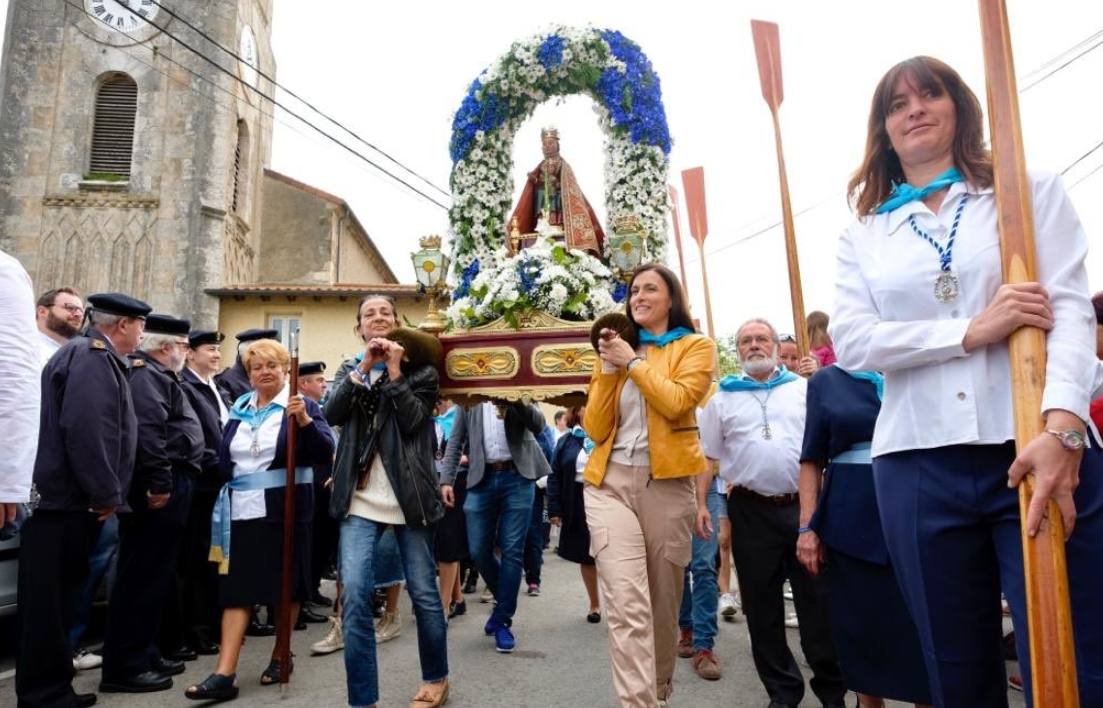 Gema Igual, a la derecha, lleva en andas a la Virgen del Mar nada más partir la imagen de la iglesia de San Román de la Llanilla.