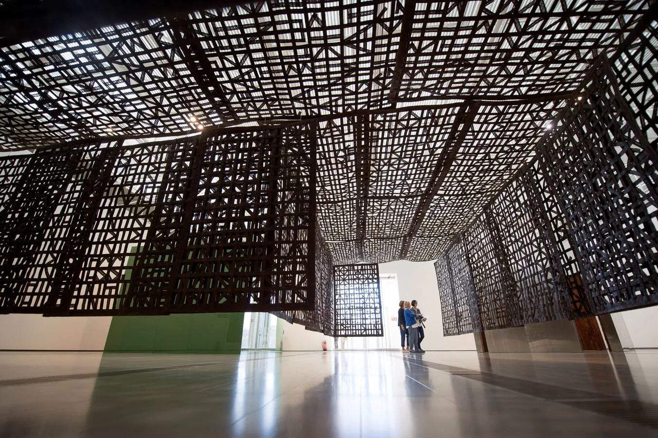 Visitantes observan una de las esculturas de la paisajista Cristina Iglesias durante la inauguración de la muestra "Entrespacios".