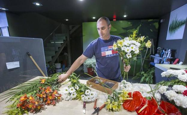 Julio Escalante trabaja preparando ramos en su taller de Flores Valdecilla