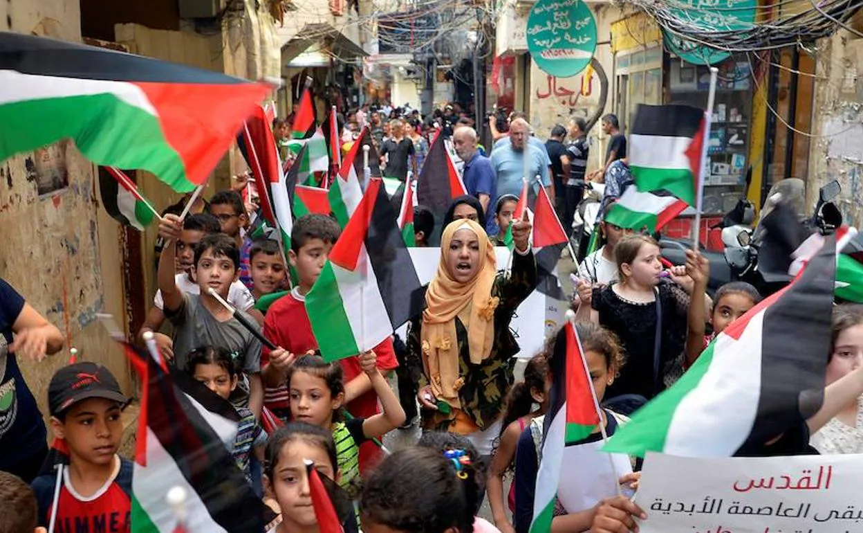 Decenas de niños sostienen banderas palestinas durante una protesta contra el foro económico 'Paz para la Prosperidad'. 