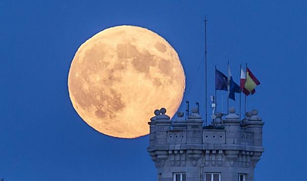 Vista de la luna llena sobre un cielo despejado con la torre del Palacio de La Magdalena, en Santander. 