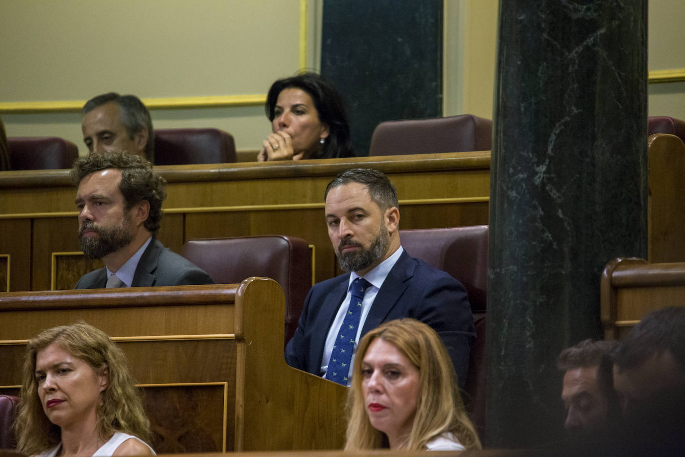 El líder de Vox observa a sus contrincantes durante la sesión de investidura.