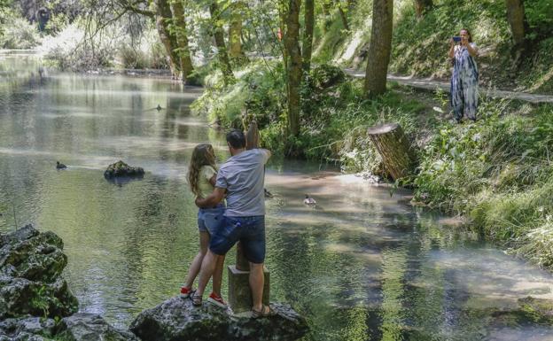 Una padre abraza a su hija junto a la virgen del Pilar para hacerse la tradicional foto en La Fuentona.