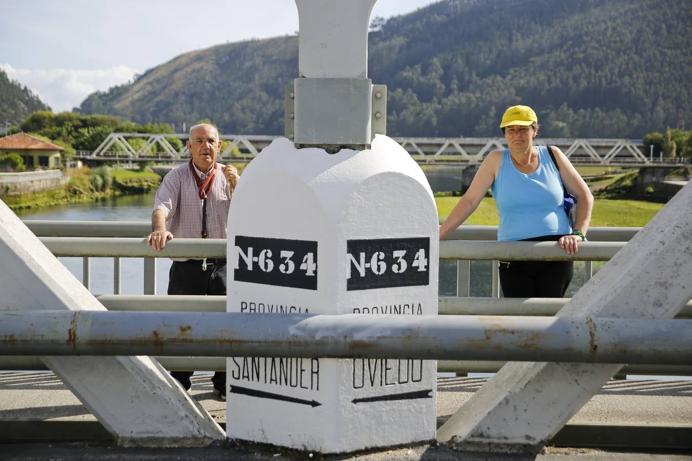 'Chirri' y Carmen posan junto al mojón que marca el límite, a mitad del puente, entre Asturias y Cantabria.