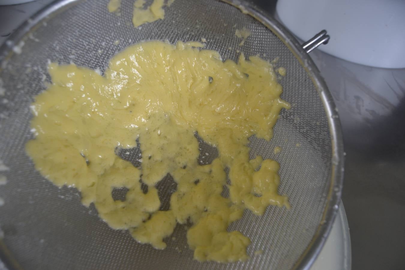 Javier Campo introduce manualmente la cuajada en los moldes para elaborar el queso.