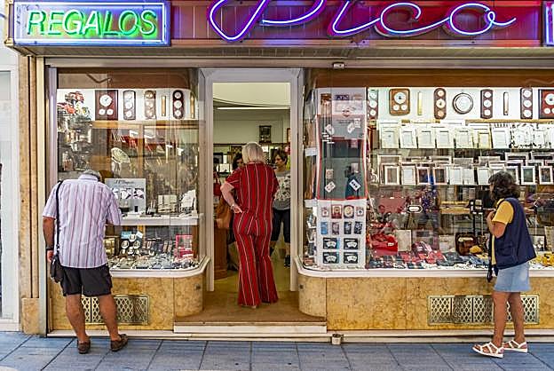 Un grupo de personas contempla el escaparate de un comercio tradicional del centro de Santander. :