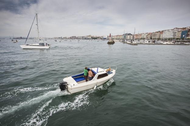 Una embarcación se aproxima y otra se aleja a la bocana de la dársena de Molnedo, ante la que se instalaría el rompeolas flotante.