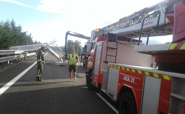 Bomberos y operarios de carreteras trabajan para retirar la señal.