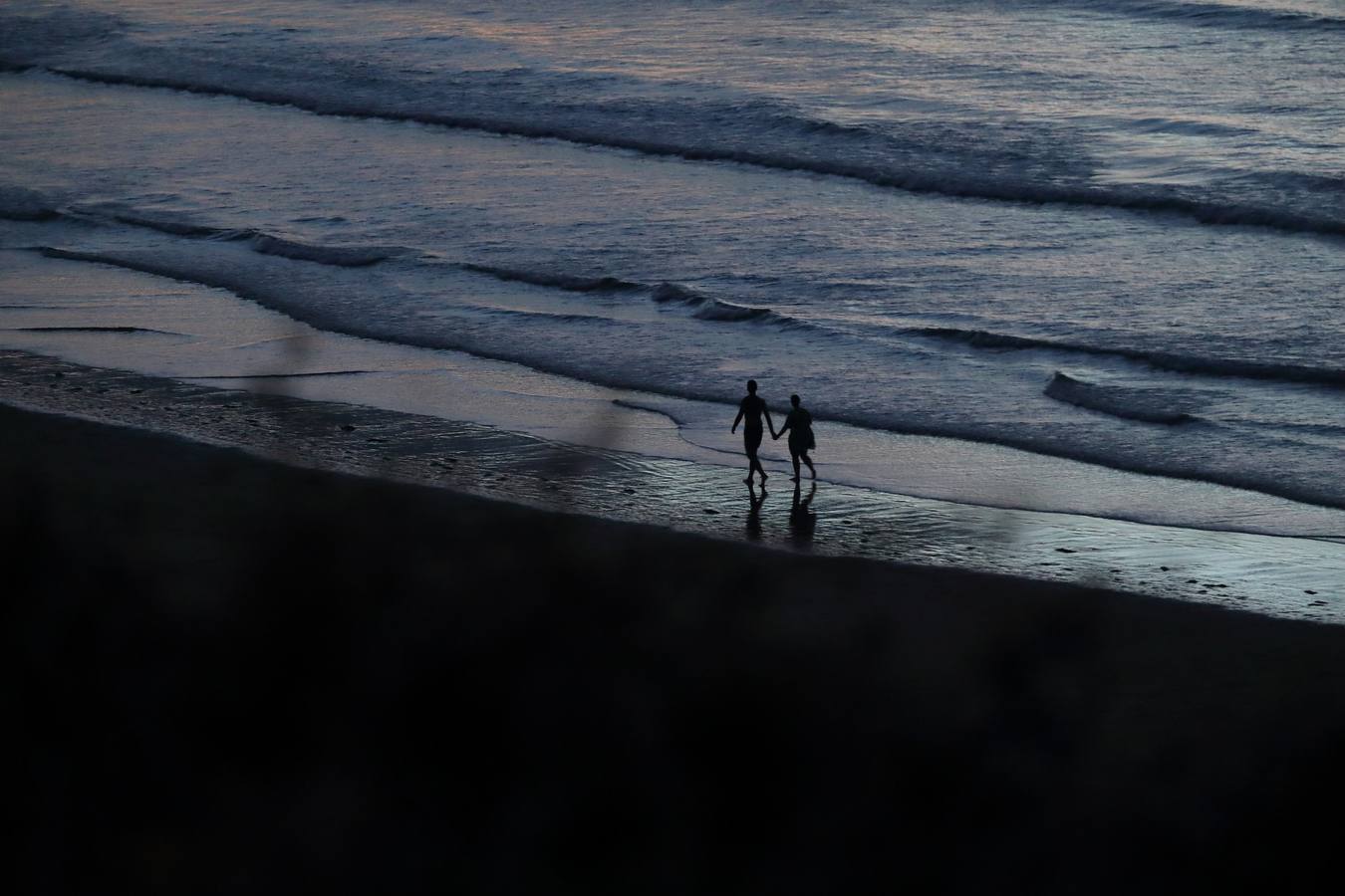 Imágenes de la playa de San Vicente de la Barquera tomadas durante la sofocante noche de este jueves