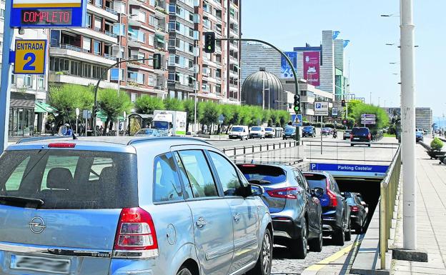 Cola para aparcar. Los conductores esperan turno parar entrar al aparcamiento de Castelar, con el cartel de 'Completo'.