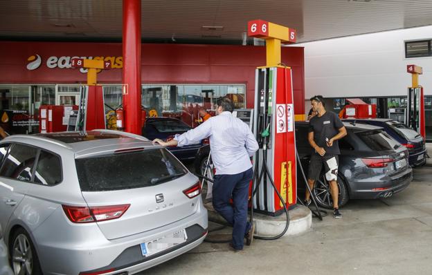 Varias personas llenan sus coches en una gasolinera de Santander durante el día de ayer, inicio de la operación salida. 