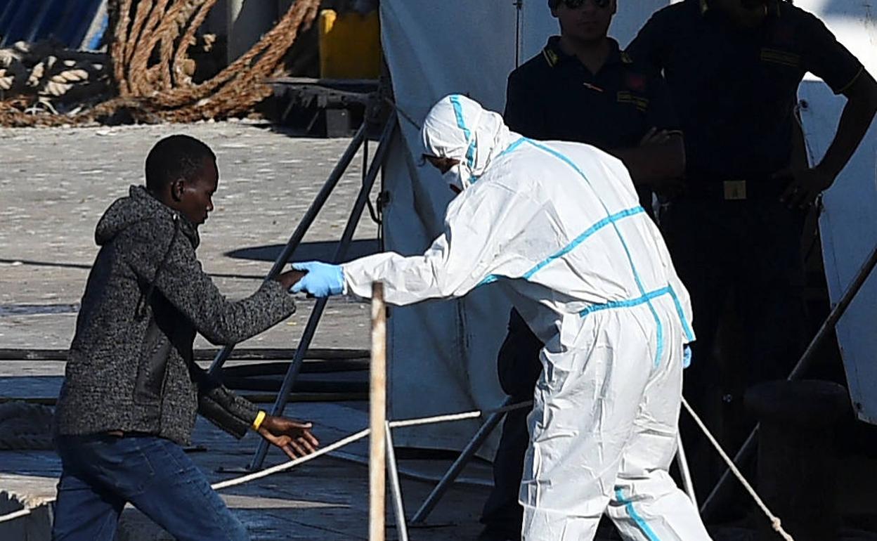 Un menor que se encontraba entre los migrantes varados en el barco de rescate de migrantes españoles Open Arms desembarca en Lampedusa, Italia.