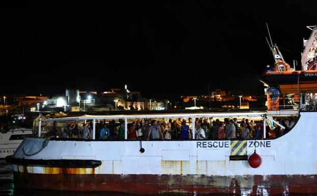 Imagen principal - El Open Arms atraca en el puerto de Lampedusa tras la orden de la Fiscalía italiana