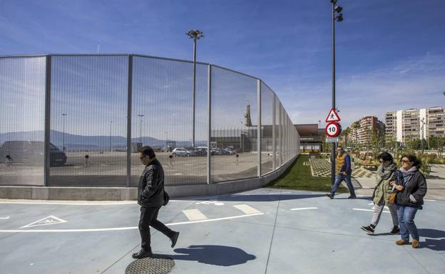 Paseantes junto a la valla del Puerto en la estación marítima, en la zona peatonal que llega hasta el Centro Botín.