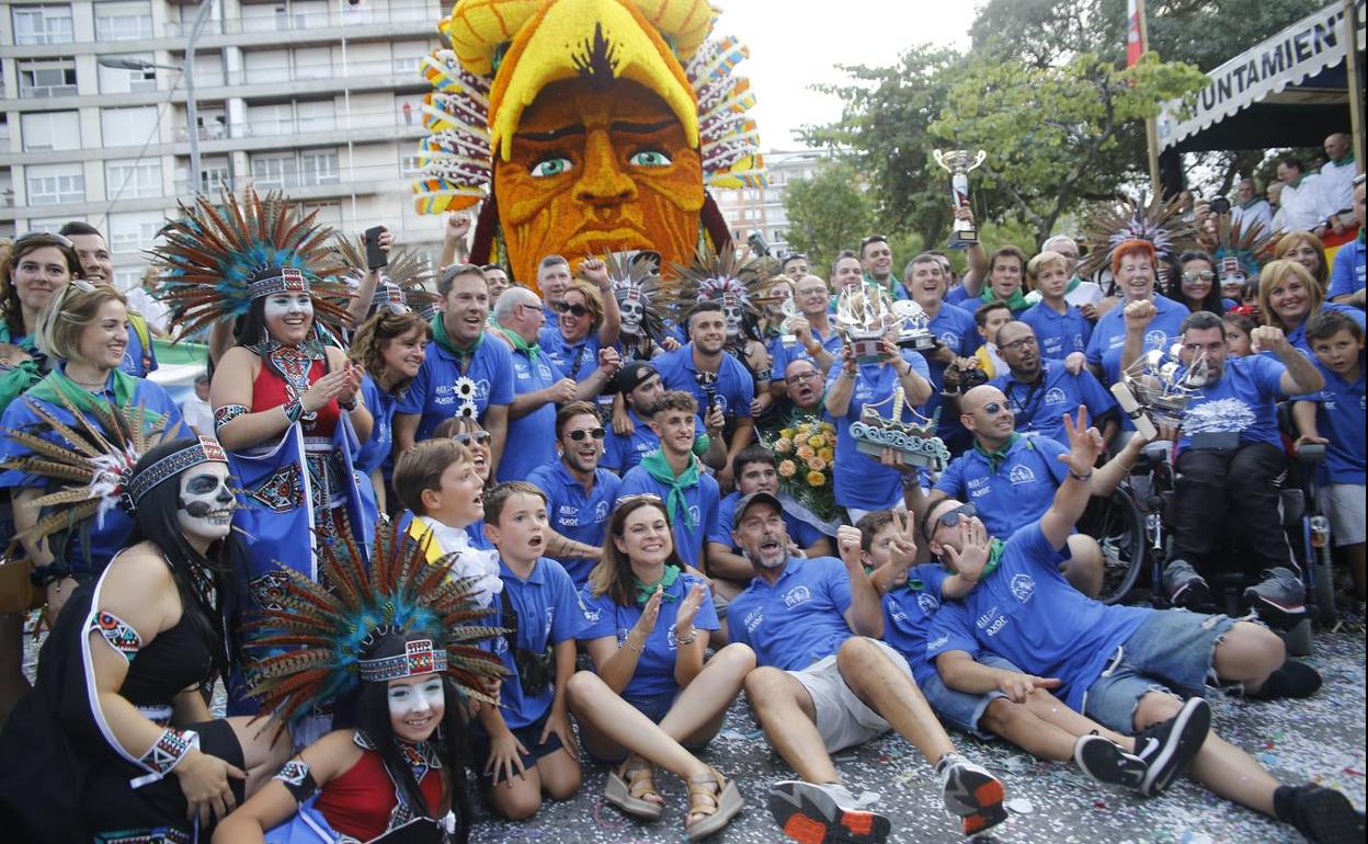 Los ganadores posan con su carroza al fondo